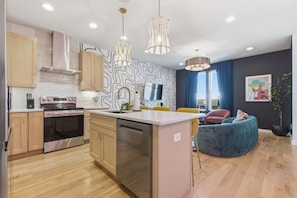 Una cocina moderna con armarios de madera, electrodomésticos de acero inoxidable y una isla central.