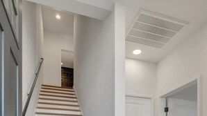 A staircase with white walls and doors, leading to an upper level.