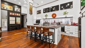 Une cuisine moderne dotée d’un îlot central, de tabourets de bar et d’un coin repas.