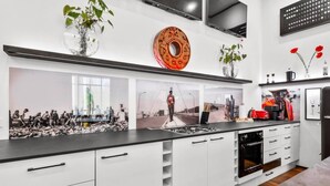 Une cuisine moderne avec des meubles blancs, un plan de travail noir et une grande fenêtre.