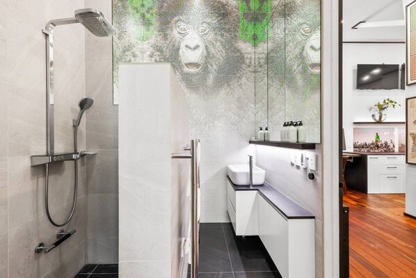 A modern bathroom with a shower, a sink, and a mirror.