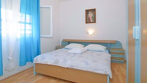 A bedroom with a bed, a nightstand, a wall-mounted light, and a painting. - 1 bedroom awesome apartment in Gradac (Gradac)
