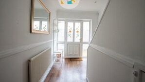 A hallway with a radiator, a mirror, and a door with frosted glass panels. - The Laurels - HS2 Contractors, NEC, BHX Airport Stays, Sleeps 12, Free Parking (Birmingham)