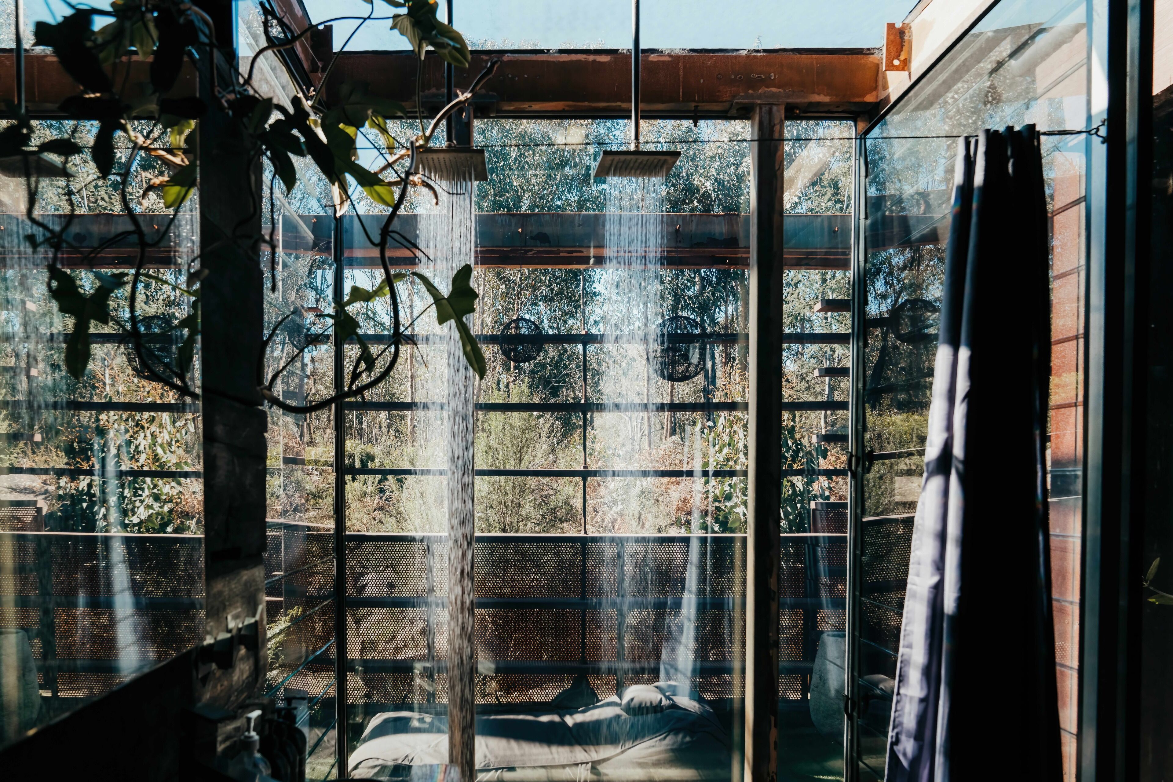 A room with a large window, a bed, and a shower area.