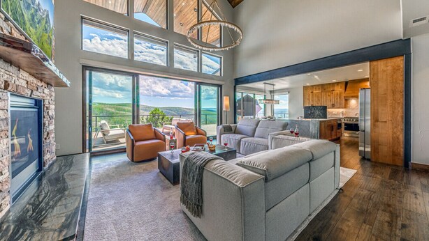 A spacious living area with a fireplace, large windows, and a view of the outdoors.