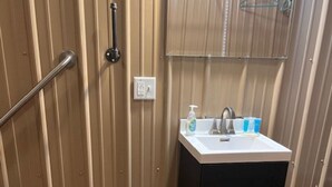 Une salle de bain avec un meuble-lavabo en bois, un évier et un miroir.