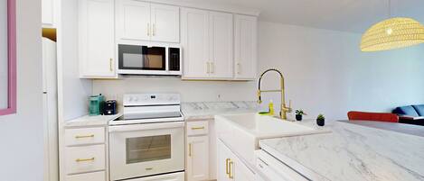 Een microgolfoven, een oven, een kookplaat, een vaatwasser