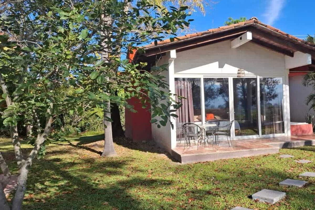 Una casa moderna con patio, puertas de vidrio y césped.