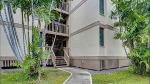Un edificio con un sendero de hormigón que conduce a una escalera de madera.