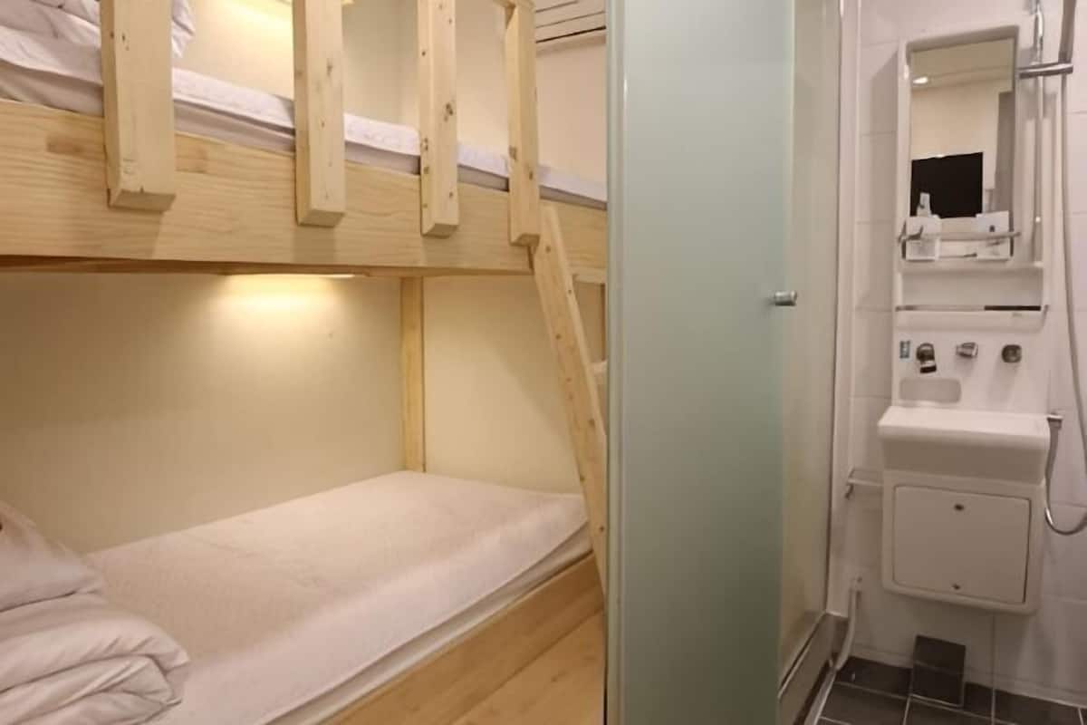 A bunk bed room with a sink and mirror.