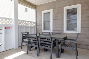 An outdoor patio with a table and chairs, a covered area, and a sign indicating spa rules.