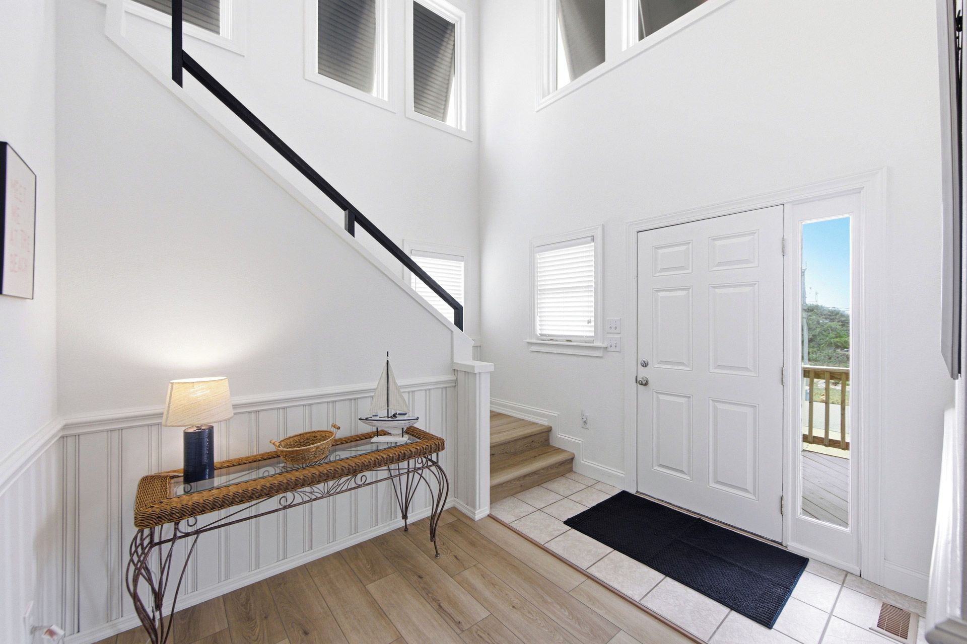 A staircase leading to a landing with a door and a view of the outdoors.