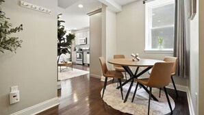 A modern kitchen with white cabinets, a microwave, and a dining area with a round table and chairs. - Modern & Cozy 2-bedroom condo in Center City Philadelphia - Walk Everywhere (Philadelphia)