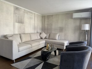 Apartamento família, sacada, vista para a cidade | Área de estar