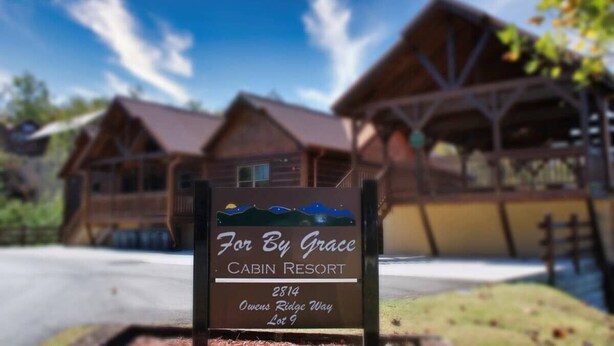 Een bord van een cabinresort met de naam 'For By Grace' en adres '2814 Owens Ridge Way, Lot 9'.