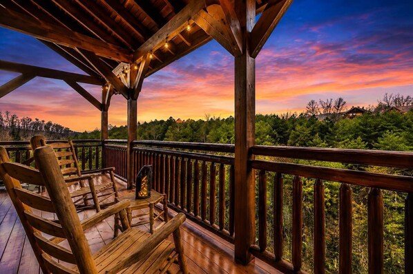 A wooden deck with a railing, a bench, and a lantern.