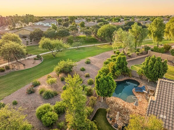 A residential area with a swimming pool, lawn, and trees. - Heated Pool Oasis | Family Retreat in Gilbert (Gilbert)