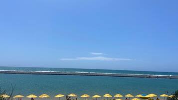 On the beach, white sand, sun loungers, beach umbrellas