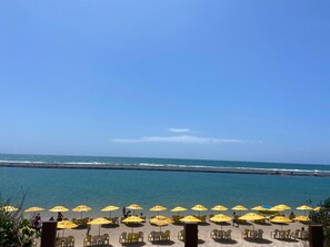 Plage, sable blanc, chaises longues, parasols