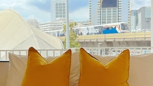 Een bed met twee kussens en uitzicht op een stadsbeeld met gebouwen en een brug.