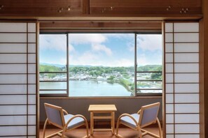 A room with a large window, two chairs, and a small table. - Wan Wan Paradise Hamanako (Hamamatsu)
