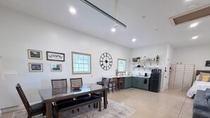 A spacious living area with a dining table, chairs, a kitchen with a refrigerator, and a bed with a headboard. - Pet-Friendly Mountain Studio - Cozy Stay with Patio & Covered Private Parking (Kingsport)
