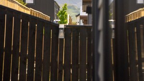 A view of a residential area with a wooden fence, a mountain in the background, and a clear sky.