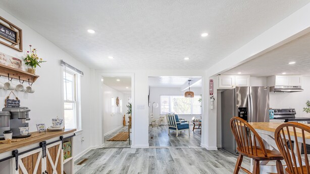 A modern kitchen with a wooden countertop, stainless steel appliances, and a dining area with wooden chairs. - House in North Rose, NY, 10 minutes from the beach (North rose)