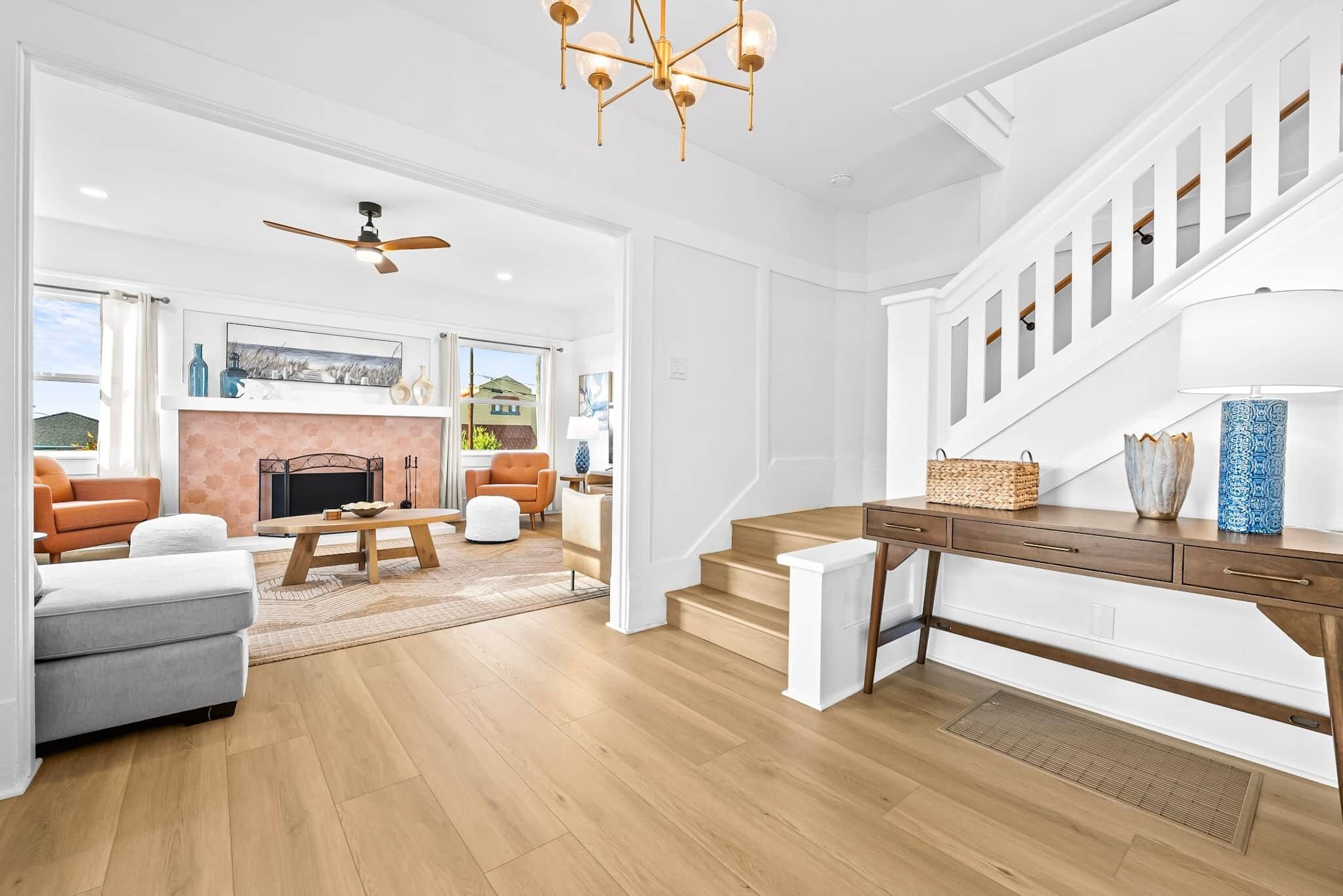 A spacious living area with a fireplace, a staircase, and a view of the outside.