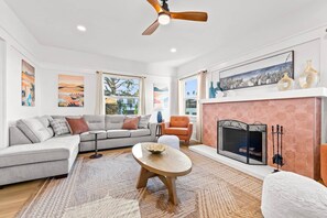 A modern living room with a sectional sofa, a round coffee table, and a fireplace.