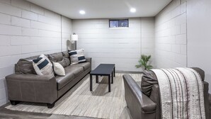 A modern living room with a sofa, a coffee table, and a small plant.