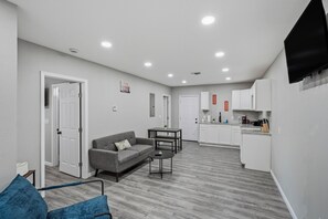 A modern apartment with a living room, kitchen, and dining area.