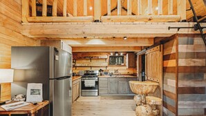 Una cucina in stile baita con frigorifero, piano cottura e tavolo da pranzo in legno.