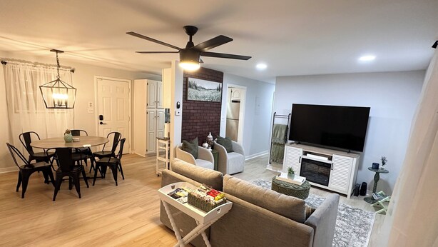 A modern living room with a dining area, a fireplace, and a TV. - Welcoming 3-bedroom house near Charlotte Airport and Uptown (Charlotte)