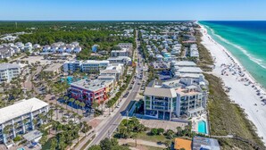 An aerial view of a coastal town with a beach, residential buildings, and a hotel with a pool. - Gulf Place 210- Steps To Beach *Snowbirds Welcome* Large Balcony (Santa Rosa Beach)