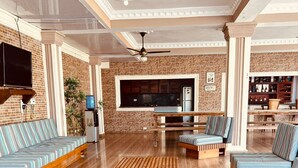A spacious living area with a wooden coffee table, striped sofas, and a brick wall. - Villas cloud 1 (Santo Domingo)