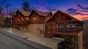 Uma cabana de toras com varanda e escadas que levam a um deck.