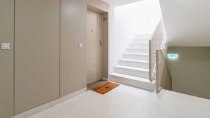 A modern hotel lobby with a staircase leading to an upper floor.