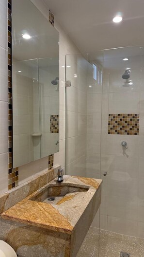 Chuveiro, toalhas de banho, sabonete, papel higiênico