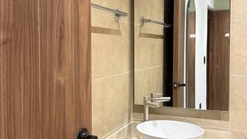 Een douche, handdoeken, zeep, toiletpapier