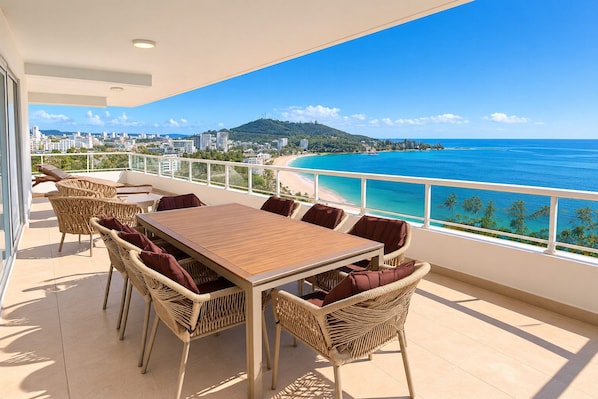 A balcony with a view of a beach and cityscape.