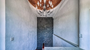 A staircase with a dark textured wall, a wooden handrail, and a white wall on one side. - Beautiful Room Villa San Juan (Nuevo Vallarta)