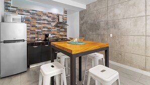 A compact kitchen with a modern design, featuring a stainless steel refrigerator, a microwave, and a stove. - Simple loft in a romantic area + Wi-Fi + beach (Puerto Vallarta)