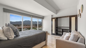 Une chambre à coucher avec un grand lit, une chaise et un meuble pour la télévision.