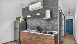 A modern kitchen with a stainless steel refrigerator, a built-in oven, and a gas stove. There are wooden cabinets and a grey backsplash. - Prime location in the Romantic Zone + beach (Puerto Vallarta)
