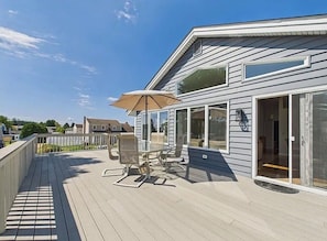 Une terrasse dotée de mobilier d’extérieur, d’une porte-fenêtre et offrant une vue sur le quartier.