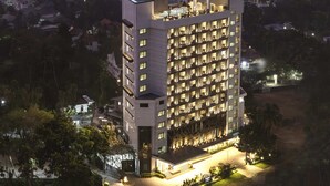 A high-rise hotel with multiple floors, a rooftop terrace, and a well-lit entrance. - Vivanta Kochi Aluva (Aluva)