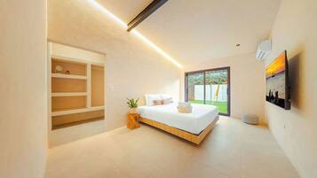 A modern bedroom with a bed, built-in shelving, a potted plant, and a large window.