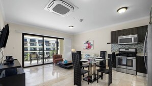 Una cocina moderna con comedor, ventanas amplias y vista al exterior del edificio.