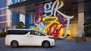 A white car parked in front of a hotel with colorful signage and a modern building facade. - K · International Hotel (Nanning)